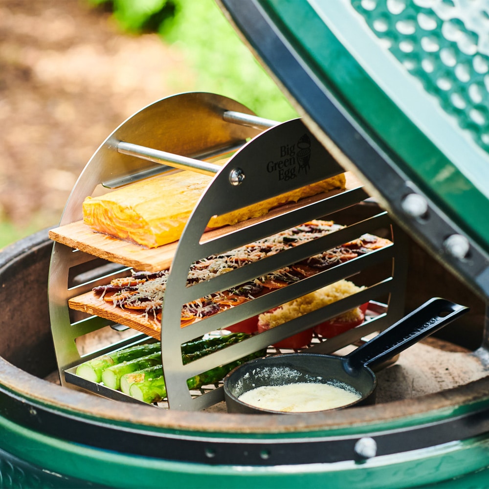 Big Green Egg füstölő torony használat közben, grillező belsejében, több szinten füstölt lazaccal, zöldségekkel és öntöttvas serpenyővel