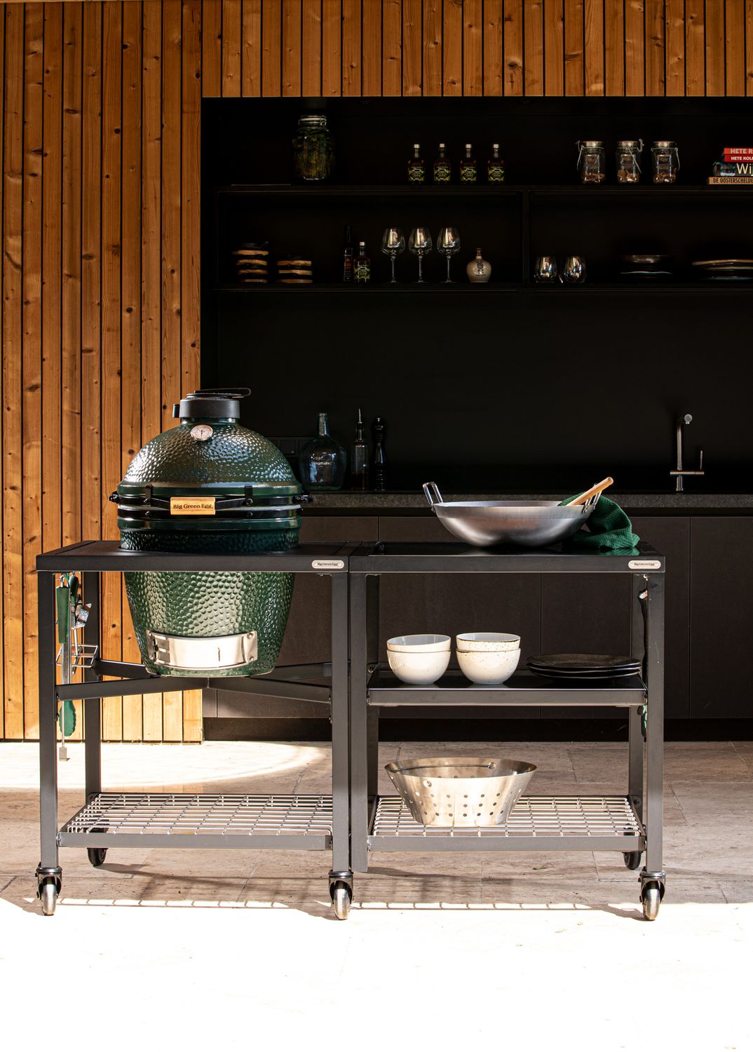 Big Green Egg moduláris kültéri asztal wokkal és vágódeszkával, modern fa burkolat előtt