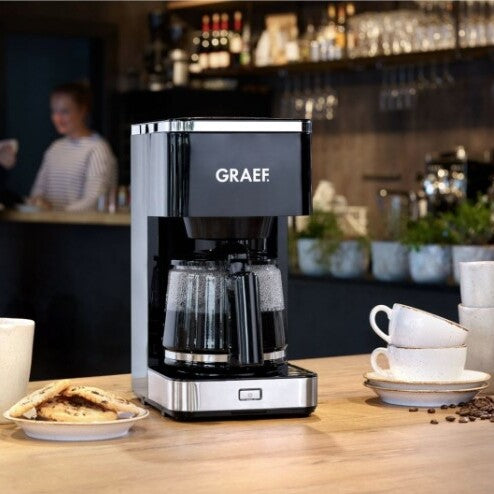 Graef FK402 filteres kávéfőző modern konyhában, üvegkannában frissen főtt kávéval és tálalt süteménnyel