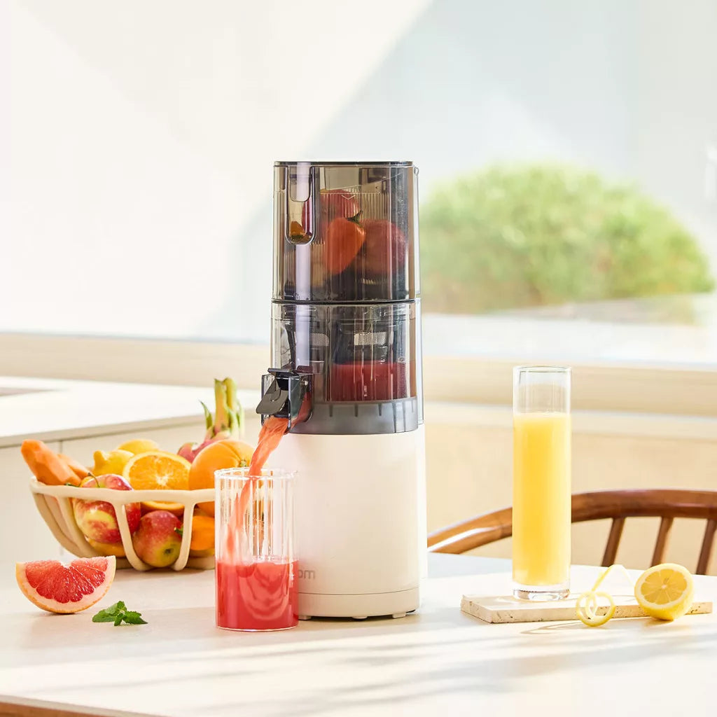 Hurom E30ST fehér lassú gyümölcsprés – friss grapefruit és narancs juice csapolása pohárba.