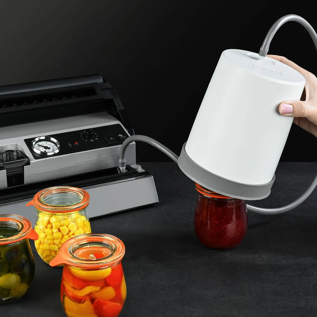 Lava Flex Jar-Sealer üveg vákuumozó adapter különböző méretű, élelmiszerrel teli üvegekkel a konyhapulton.
