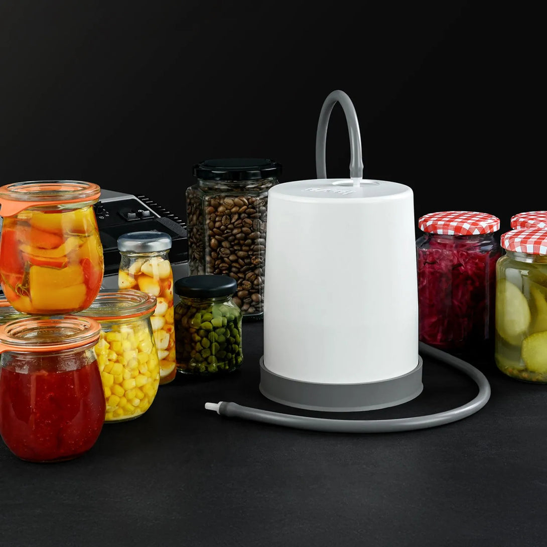 Jar-Sealer ráhelyezése egy lekváros üvegre, csatlakoztatva a vákuumgépen lévő külső porthoz, vákuumozás közben.
