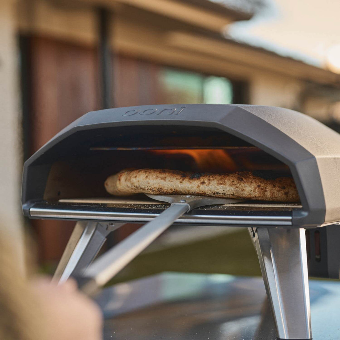 Ooni Koda 2 pizzakemence közelről, pizza betolása közben

