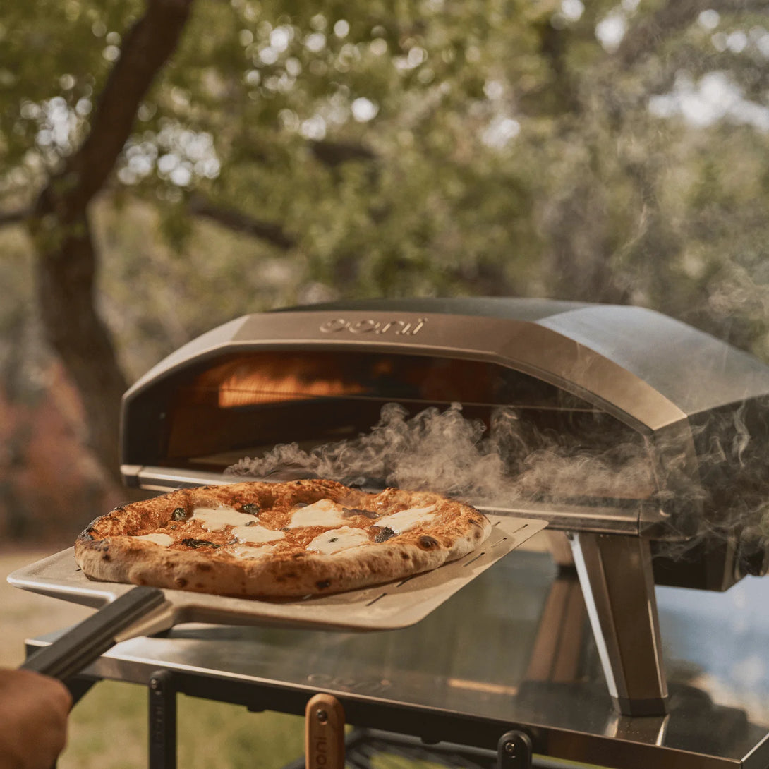 Ooni Koda 2 Pro kemence sütés közben, elölről fotózva, alatt Ooni pizzalapát látható

